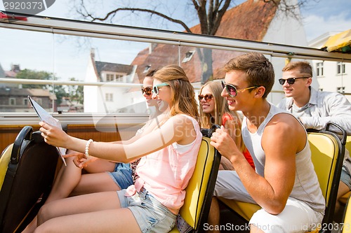 Image of group of smiling friends traveling by tour bus