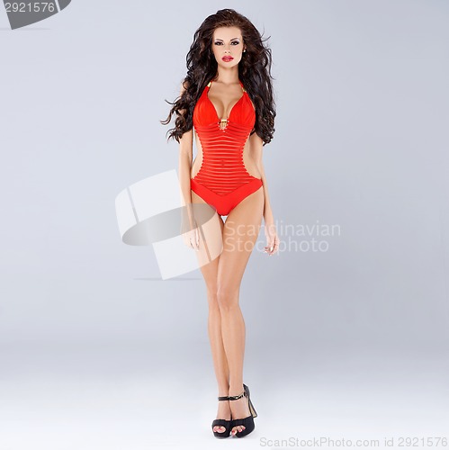 Image of Sexy sensual brunette posing in red swimsuit