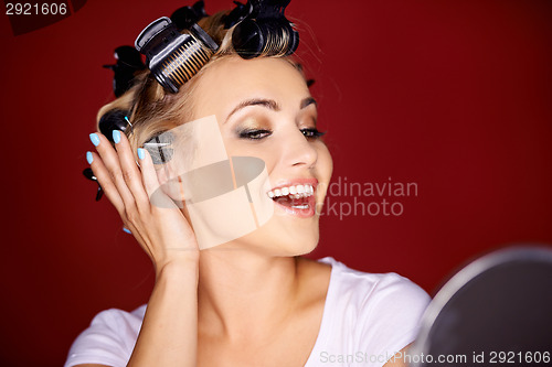 Image of Young woman primping in front of a mirror