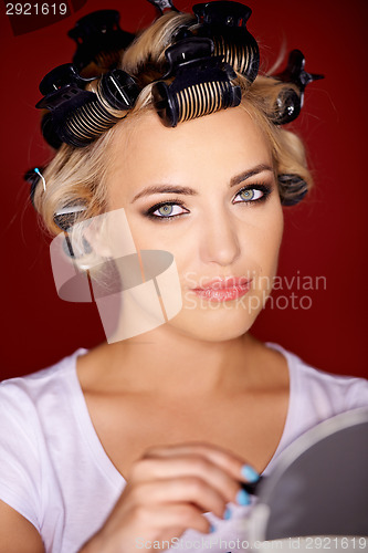 Image of Beautiful young blond with her hair in curlers