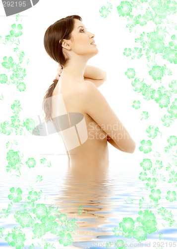 Image of topless brunette in water with flowers looking up #2