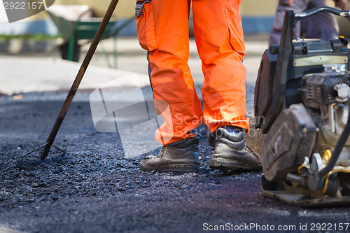 Image of Asphalt surfacing manual labor.