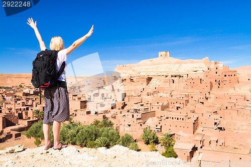 Image of Traveler arms reised in front of Ait Benhaddou, Morocco.