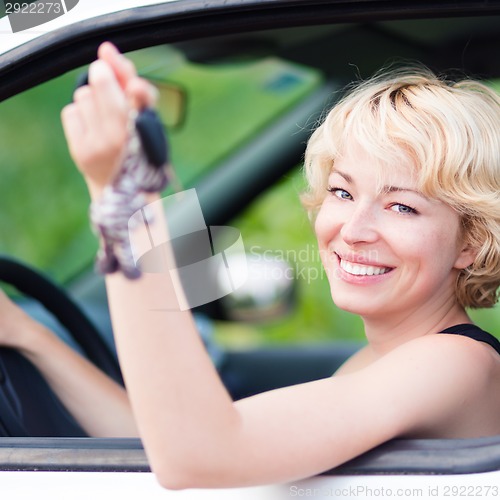 Image of Lady, driving showing car keys out the window.