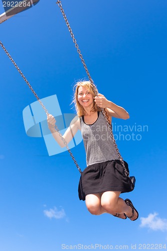 Image of Woman swinnging on a swing.
