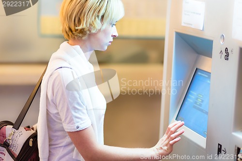 Image of Lady using ticket vending machine.