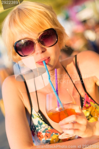 Image of Cute young lady  drinking cocktail.