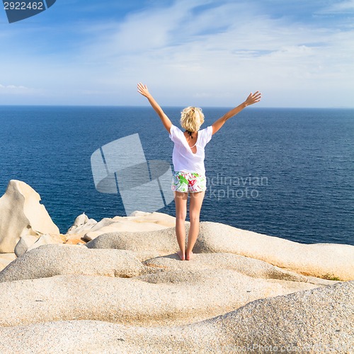 Image of Woman practicing yoga at the beach.