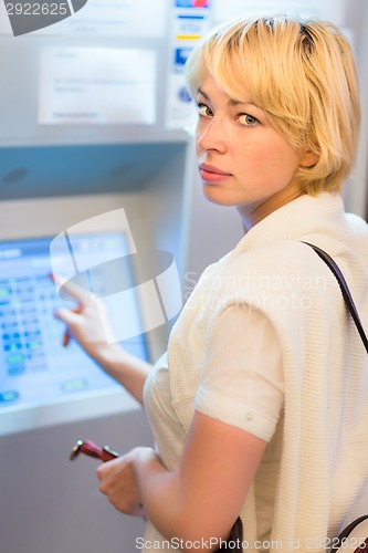 Image of Lady using ticket vending machine.