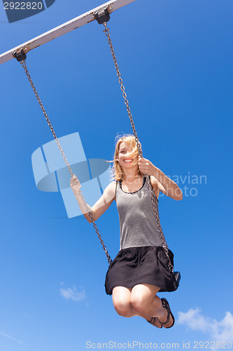 Image of Woman swinnging on a swing.
