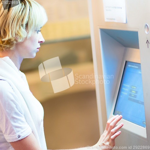 Image of Lady using ticket vending machine.