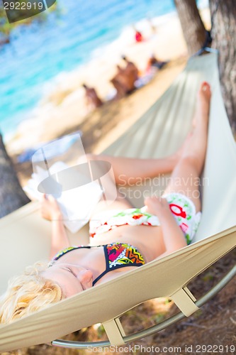Image of Lady napping on hammock at the beach.