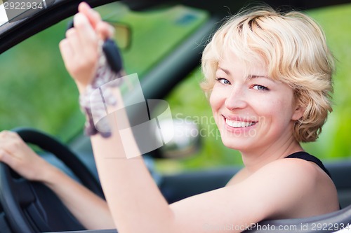 Image of Lady, driving showing car keys out the window.