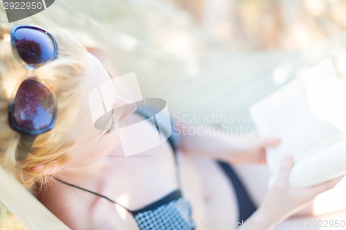 Image of Lady reading a book in a hammock.