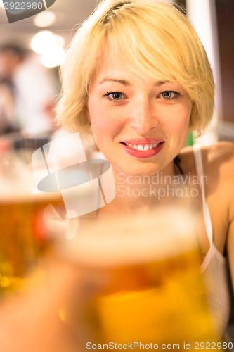 Image of Lady toasting with a pint of beer.