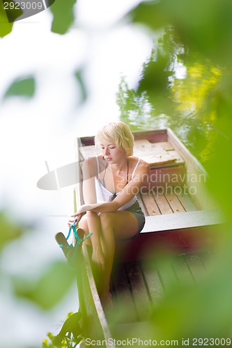 Image of Thoughtful woman on the vintage wooden boat.