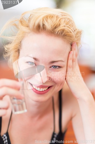 Image of Lady having a shot of spirit drink.