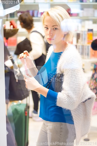 Image of Woman buying nail polish in perfumery.