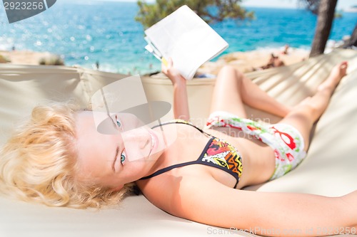 Image of Beautiful girl lies on hammock on the beach