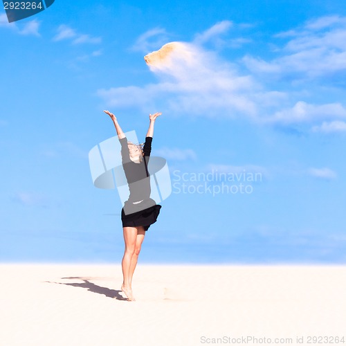 Image of Playful girl throwing sand in the air.