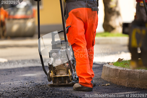 Image of Asphalt surfacing manual labor.