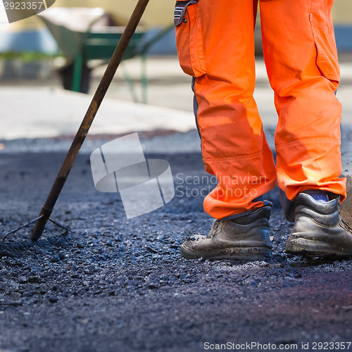 Image of Asphalt surfacing manual labor.