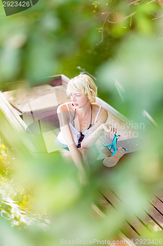 Image of Thoughtful woman on the vintage wooden boat.