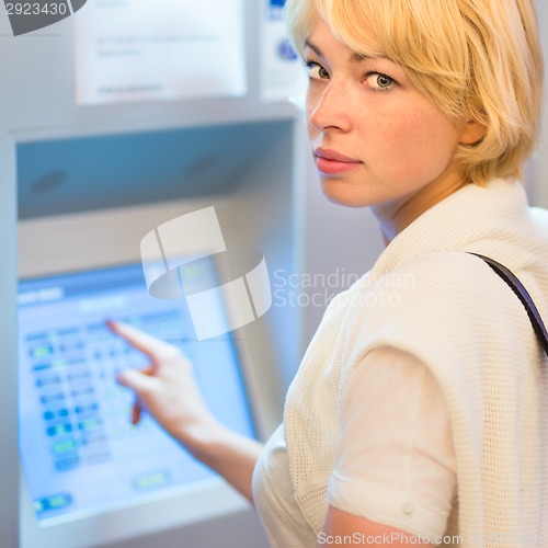 Image of Lady using ticket vending machine.