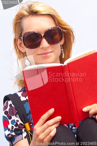 Image of Attractive young lady reading a book.