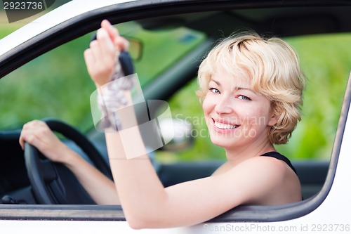 Image of Lady, driving showing car keys out the window.