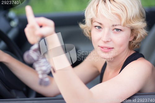 Image of Lady, driving showing car keys out the window.