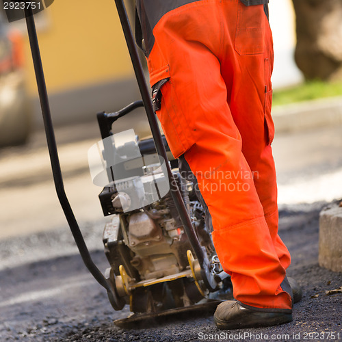 Image of Asphalt surfacing manual labor.