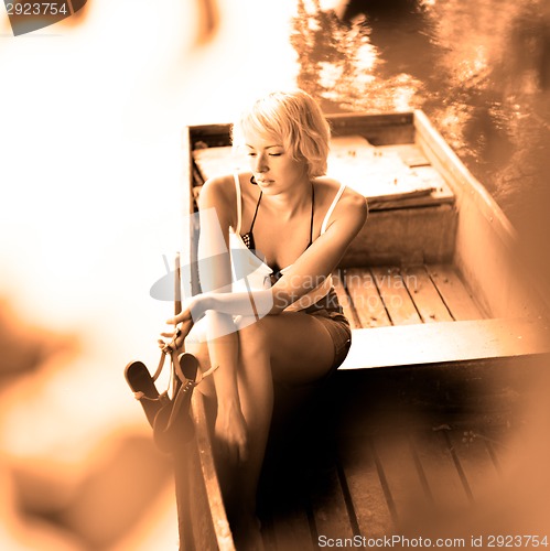 Image of Woman relaxing on the vintage wooden boat.