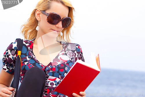 Image of Attractive young lady reading a book.