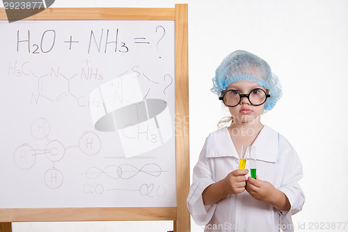 Image of Chemist girl in points and with the tubes at board