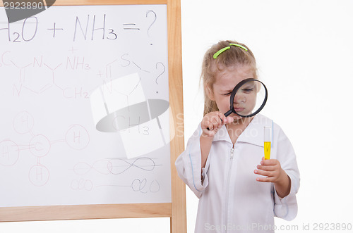 Image of Chemist closely examines the liquid in a test tube