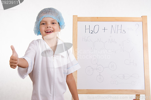 Image of Chemist girl stands at the blackboard and shows class