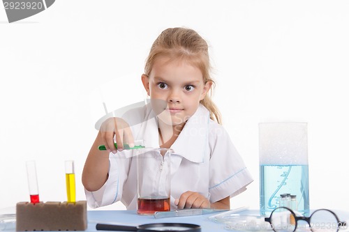 Image of Mad Chemist pours green liquid in a flask