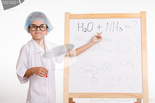 Image of Trainee in chemistry class shows at the formulas on a blackboard