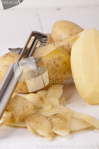 Image of Potatoes with Peeler and Peeled Skin