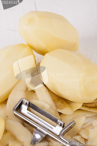 Image of Potatoes with Peeler and Peeled Skin