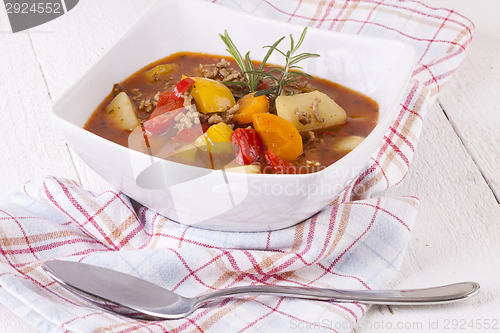 Image of Hearty Stew in Bowl and Spoon on Plaid Dish Towel