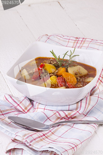 Image of Hearty Stew in Bowl and Spoon on Plaid Dish Towel