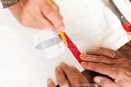 Image of Hand Cutting Cloth with Scissors