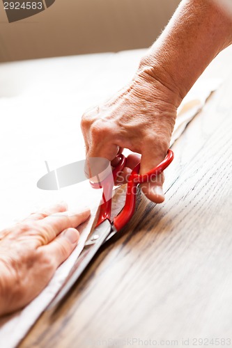 Image of Hand Cutting Cloth with Scissors