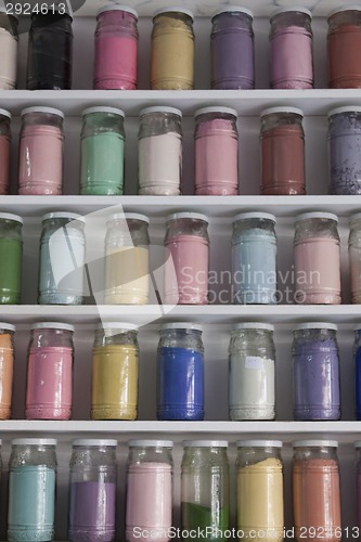 Image of Shelving with glass jars of colorful pigments