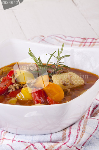 Image of Hearty Stew in Bowl and Spoon on Plaid Dish Towel