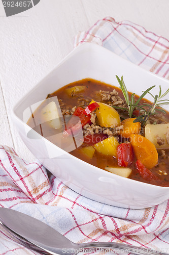 Image of Hearty Stew in Bowl and Spoon on Plaid Dish Towel