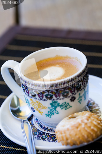 Image of Cup of freshly brewed tea and a cookie