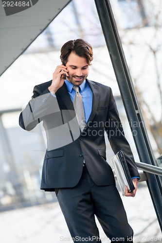 Image of Businessman listening to a call on his mobile